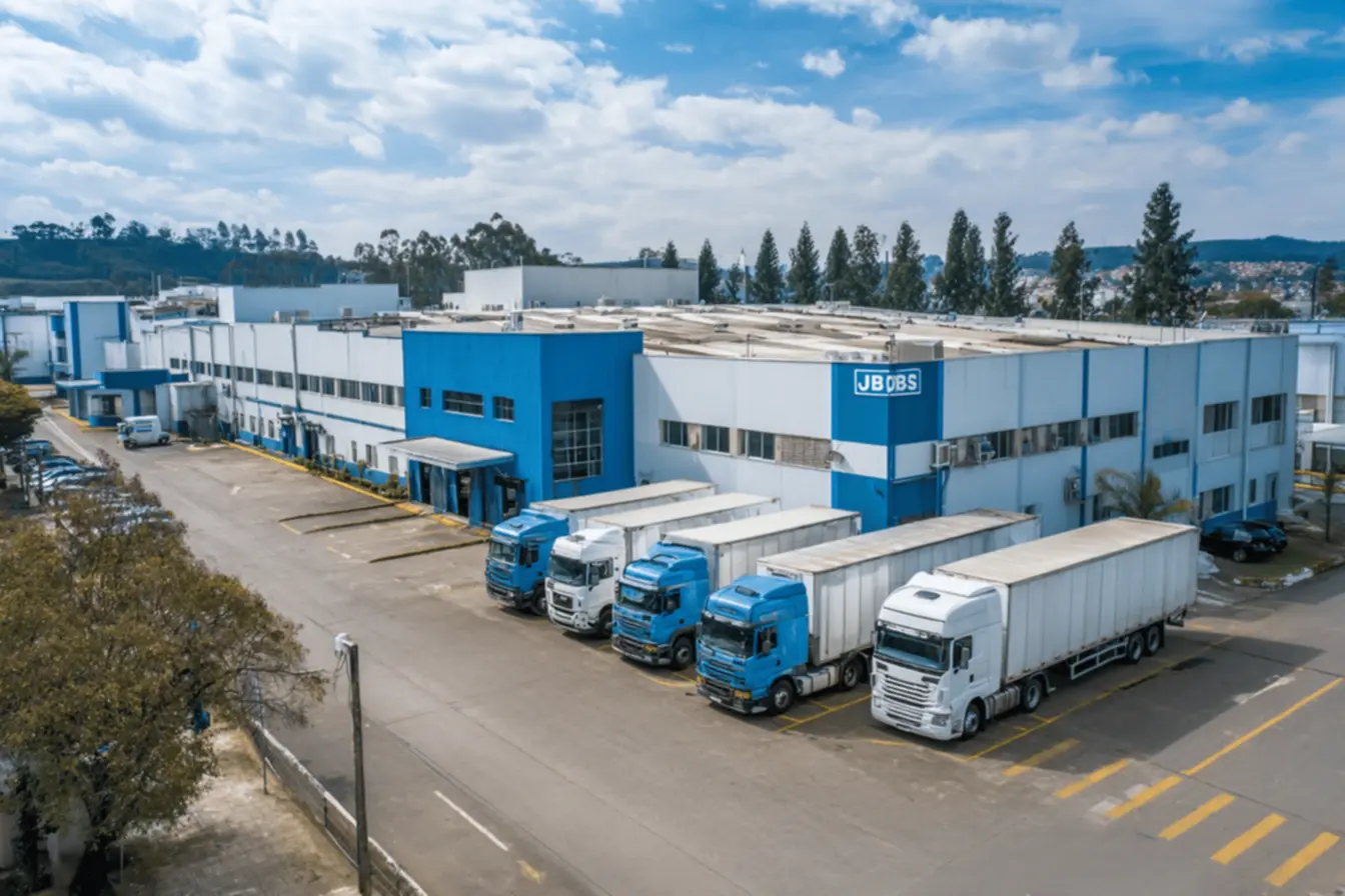 Funcionários da JBS trabalhando em uma linha de processamento de carne, evidenciando a mão de obra nos Frigoríficos JBS Brasil.